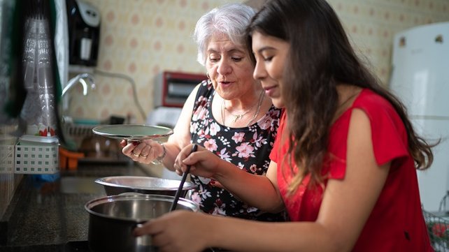 Grandmother teaching grandchild to cook