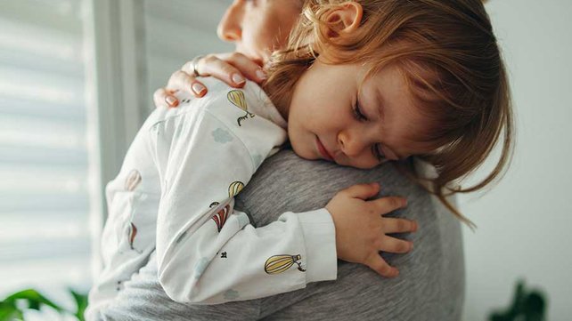 Child sleeping on parents shoulder