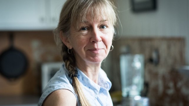 Woman in kitchen smiling
