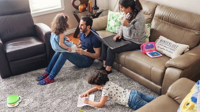 Mother and father spending family time with young son and daughter in living room