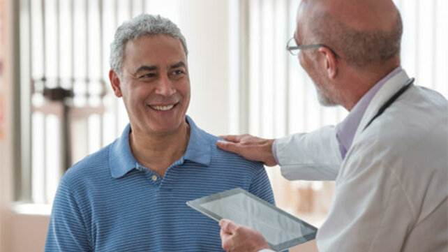 doctor with tablet, with hand on patient shoulder